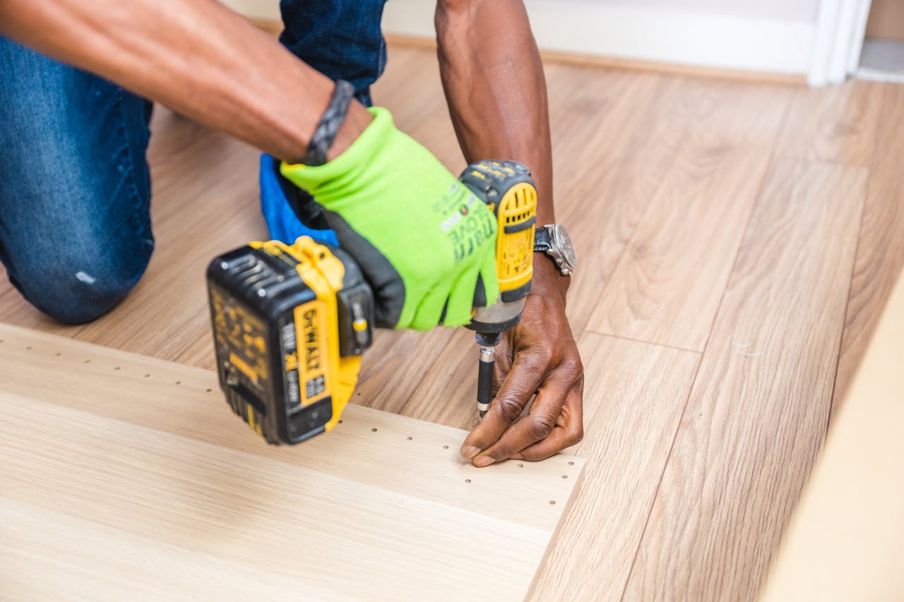 Crafting Captivating Headlines: Your awesome post title goes here Close-up of handyman drilling wood indoors with green gloves and cordless drill.